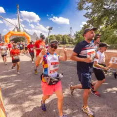Läufer beim b2run Munich, eine Frau gibt Daumen hoch.