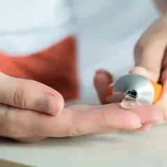 Eine Hand drückt eine Tube aus, um eine klare Salbe auf die andere Hand zu geben. Hilft bei Muskelkater, z.B. mit Ibuprofen.