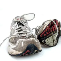 Abgenutzte Laufschuhe auf weißem Hintergrund. Die Sohlen zeigen Verschleiß, was Fragen aufwirft, wie lange halten laufschuhe wirklich?