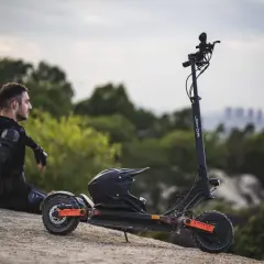 Mann in Schutzkleidung sitzt neben E-Roller mit Helm. Der e roller preis pro minute ist hier nicht ersichtlich, aber die Fahrt verspricht Abenteuer.