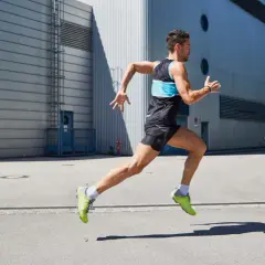 Ein Mann in Sportkleidung läuft dynamisch. Er konzentriert sich darauf, richtig laufen zu lernen, um seine Leistung zu verbessern.