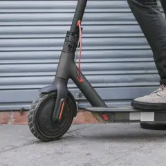 Ein Mann steht auf einem E-Scooter. Die Frage, ob man einen E-Scooter orten kann, beschäftigt viele Nutzer.