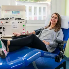 Frau lächelt während der Plasmaspende. Danach fühlt sie sich fit für Sport.