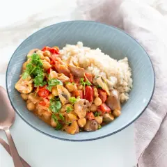 Ein köstliches, proteinreiches Abendessen: Kichererbsen-Curry mit Pilzen, Tomaten und Reis, garniert mit frischer Petersilie.