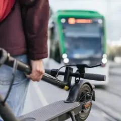 Person mit E-Scooter wartet auf die S-Bahn.