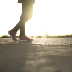 Beine in Laufschuhen, die im warmen Abendlicht japanisch gehen.