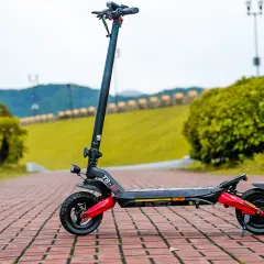 Schwarzer E-Scooter mit roten Akzenten auf Kopfsteinpflaster. Hier erfahren Sie, wie Sie die e-scooter fahrgestellnummer finden.