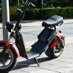 Roter E-Scooter mit Sitz, bereit für die Fahrt. Für diesen Roller ist eine e scooter fahrerlaubnis erforderlich.