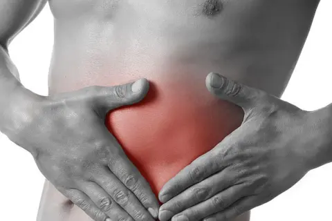 Hände umfassen den Bauch, wo ein roter Bereich auf einen stechenden Schmerz rechts hinweist.