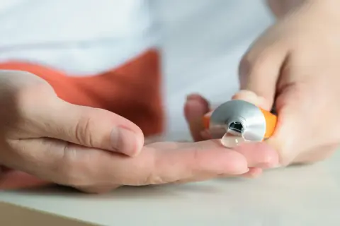 Eine Hand drückt eine Tube aus, um eine klare Salbe auf die andere Hand zu geben. Hilft bei Muskelkater, z.B. mit Ibuprofen.