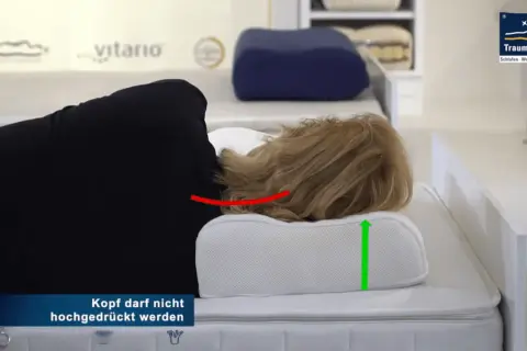 Frau liegt auf einem ergonomischen Kissen, das den Nacken bei HWS-Syndrom stützt. Der Kopf wird nicht hochgedrückt.