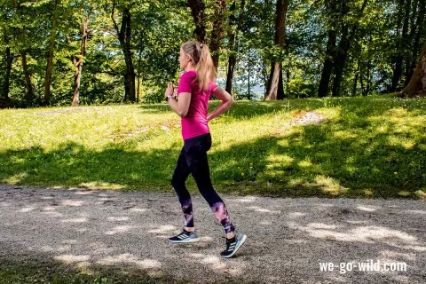 Frau im Park beim warm up laufen, genießt die Natur.