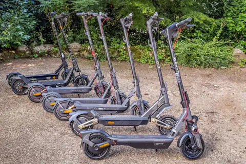 Mehrere E-Scooter stehen nebeneinander im Freien. Sie sind bereit für die e scooter zulassung deutschland.