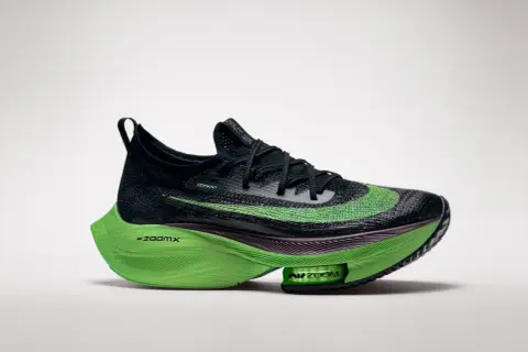 Schwarzer Laufschuh mit leuchtend grüner Sohle und Swoosh. Diese verbotene laufschuhe versprechen Höchstleistungen.