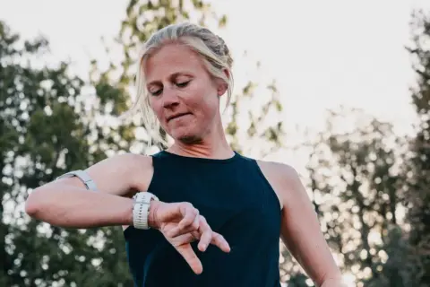 Läuferin prüft ihre Uhr, bereit für einen Ultramarathon in Deutschland.