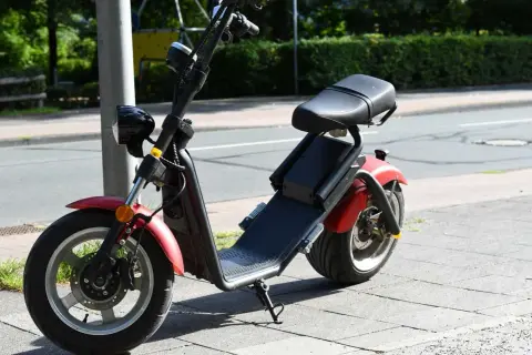 Roter E-Scooter mit Sitz, bereit für die Fahrt. Für diesen Roller ist eine e scooter fahrerlaubnis erforderlich.