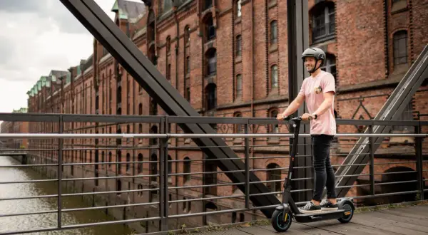 Mann auf Ninebot G30D E-Scooter in Hamburg. Die lange **Ninebot G30D Akku Lebensdauer** ermöglicht Erkundungstouren durch die Speicherstadt.