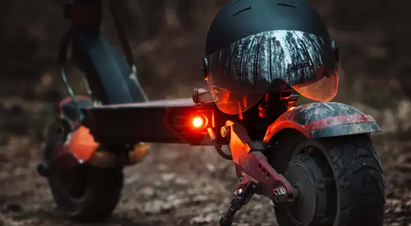 E-Scooter mit leuchtendem Rücklicht und Helm. Die e-scooter blinker pflicht ist wichtig für die Sicherheit im Straßenverkehr.