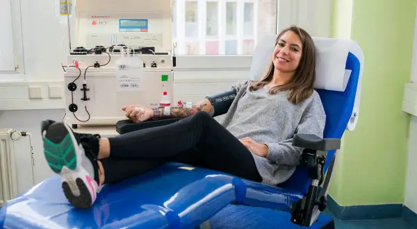 Frau lächelt während der Plasmaspende. Danach fühlt sie sich fit für Sport.