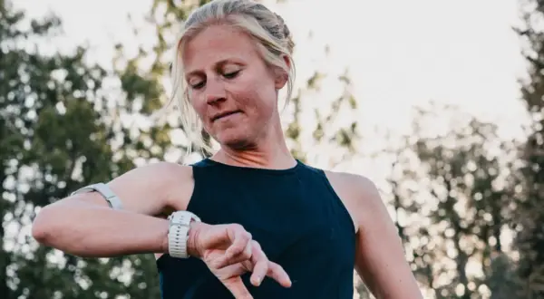 Läuferin prüft ihre Uhr, bereit für einen Ultramarathon in Deutschland.