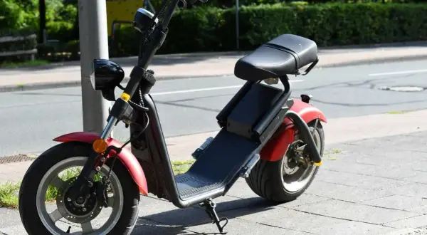 Roter E-Scooter mit Sitz, bereit für die Fahrt. Für diesen Roller ist eine e scooter fahrerlaubnis erforderlich.