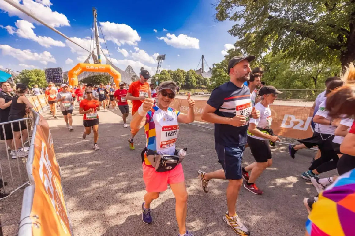 Läufer beim b2run Munich, eine Frau gibt Daumen hoch.