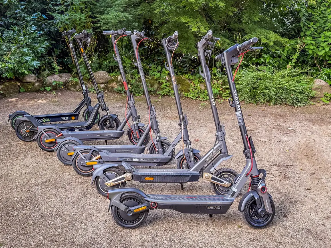Mehrere E-Scooter stehen nebeneinander im Freien. Sie sind bereit für die e scooter zulassung deutschland.