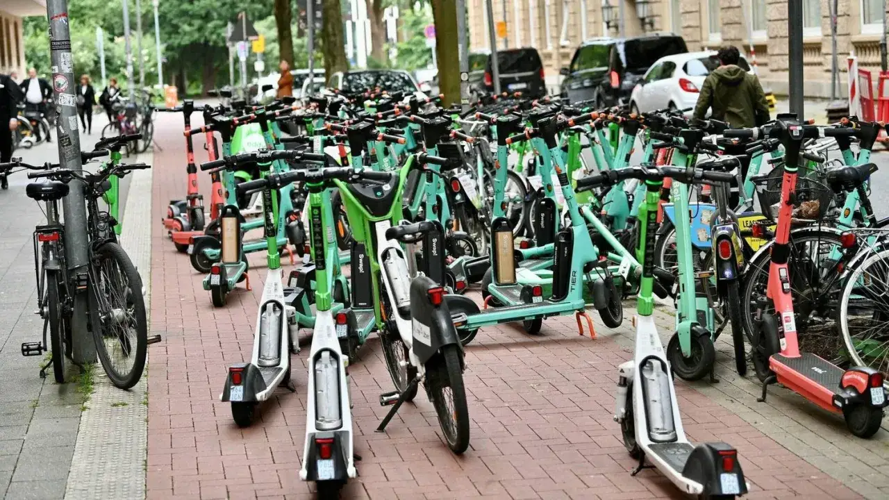 Viele E-Scooter stehen nebeneinander auf einem Gehweg. Sie sind bereit f&uuml;r die n&auml;chste Fahrt, sobald jemand seine e scooter erlaubnis hat.