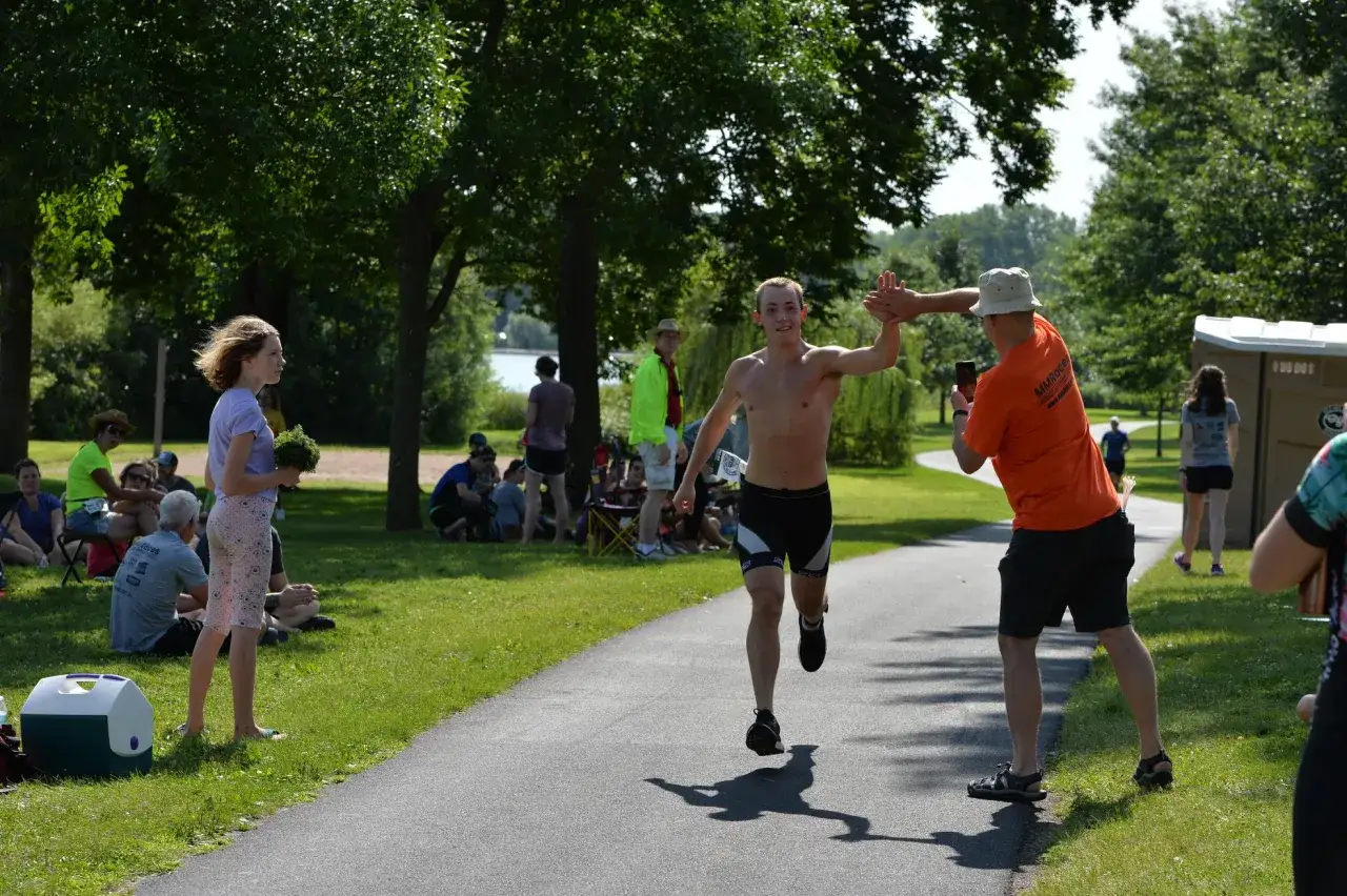L&auml;ufer gibt High-Five w&auml;hrend der taper week. Zuschauer am Rand feuern an.