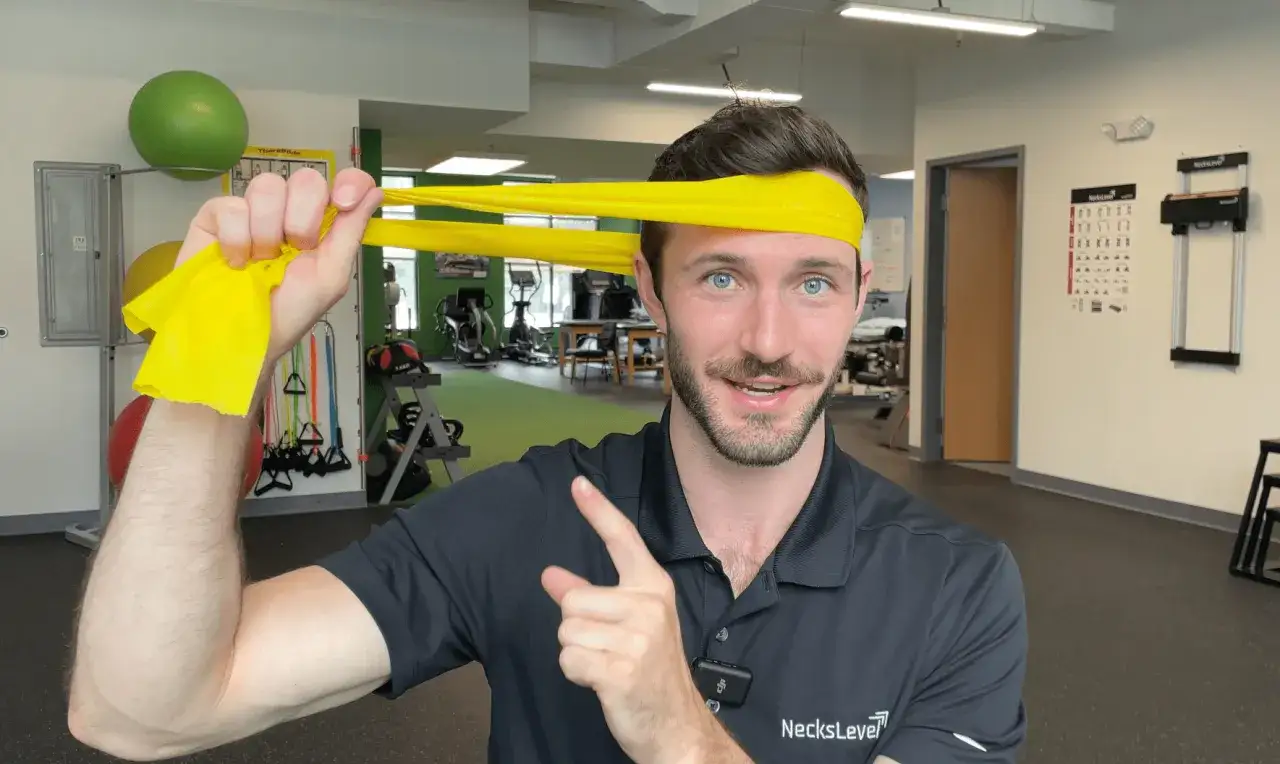 Mann mit gelbem Widerstandsband um den Kopf, zeigt auf &Uuml;bung f&uuml;r Krafttraining bei HWS-Syndrom.
