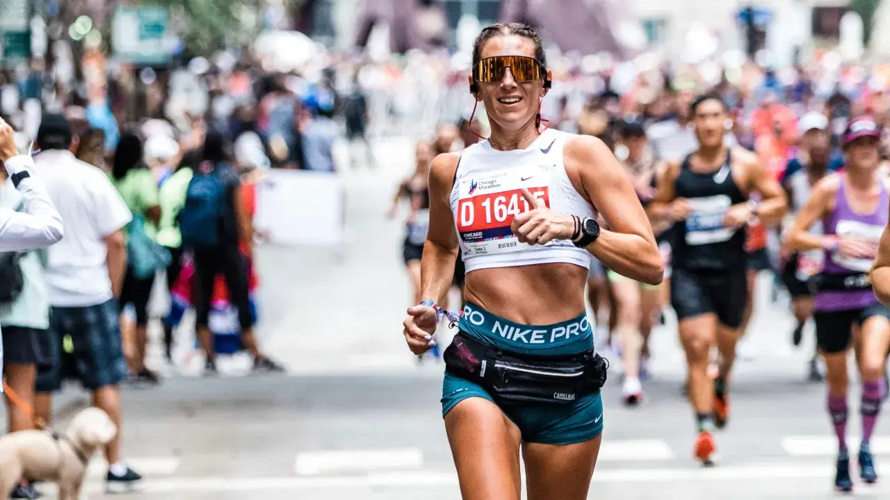 Ruth Chepngetich gibt Daumen hoch beim Chicago Marathon. Sie trägt eine Startnummer D 16415 und Nike Pro Kleidung.