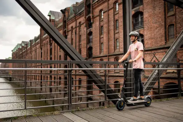 Mann auf Ninebot G30D E-Scooter in Hamburg. Die lange **Ninebot G30D Akku Lebensdauer** ermöglicht Erkundungstouren durch die Speicherstadt.