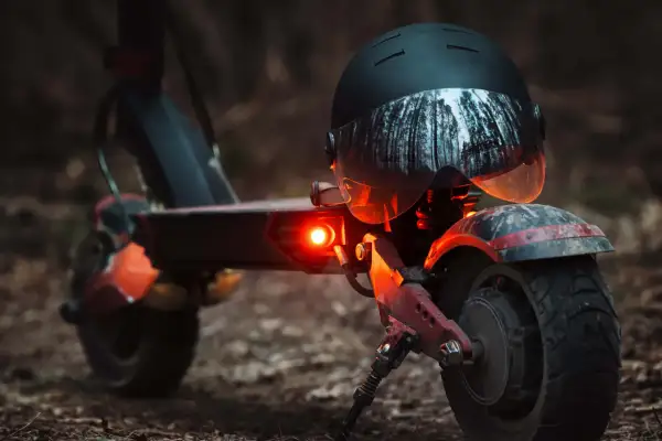 E-Scooter mit leuchtendem Rücklicht und Helm. Die e-scooter blinker pflicht ist wichtig für die Sicherheit im Straßenverkehr.