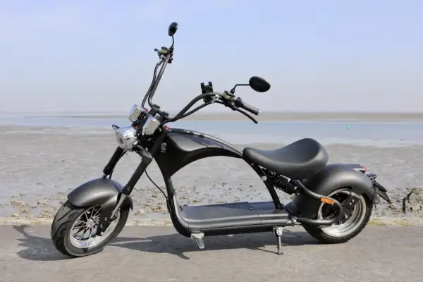 Schwarzer E-Scooter im Chopper-Stil am Strand der Niederlande. Ab wann darf man damit fahren?